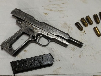 La pistola ritrovata dai detenuti di Rebibbia impegnati nella cura delle aree verdi di Roma