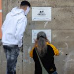 ragazzo di Casal Del Marmo che illustra il murale ai visitatori